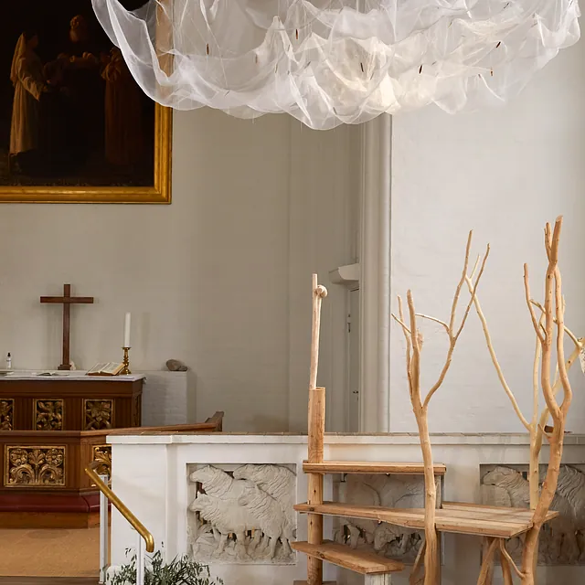En kunstinstallation i en kirke med en svævende netsky.