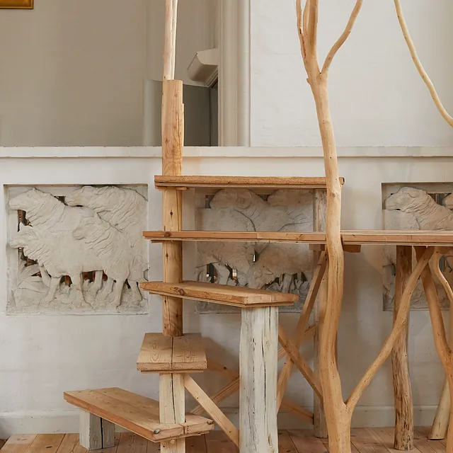 Trætrapper og grene danner en kunstinstallation i kirken.